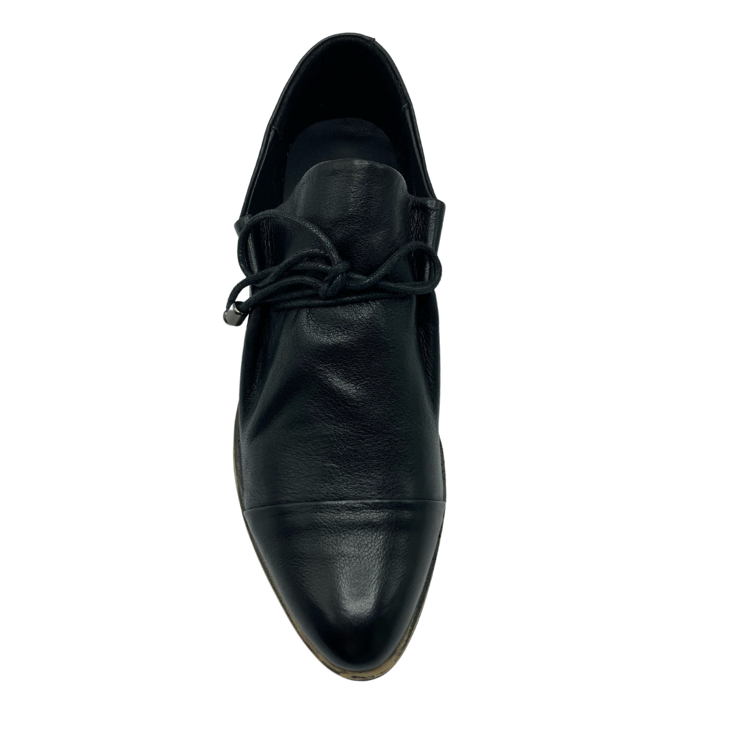 Top view of black leather shoe with pointed toe and black laces