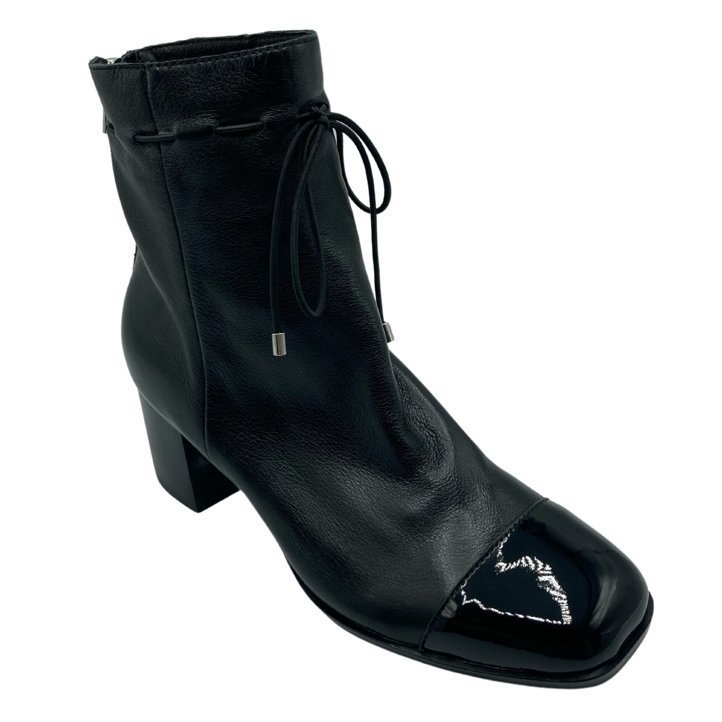 45 degree angled view of black leather ankle boot with patent leather toe cap. Square toe and black heel.