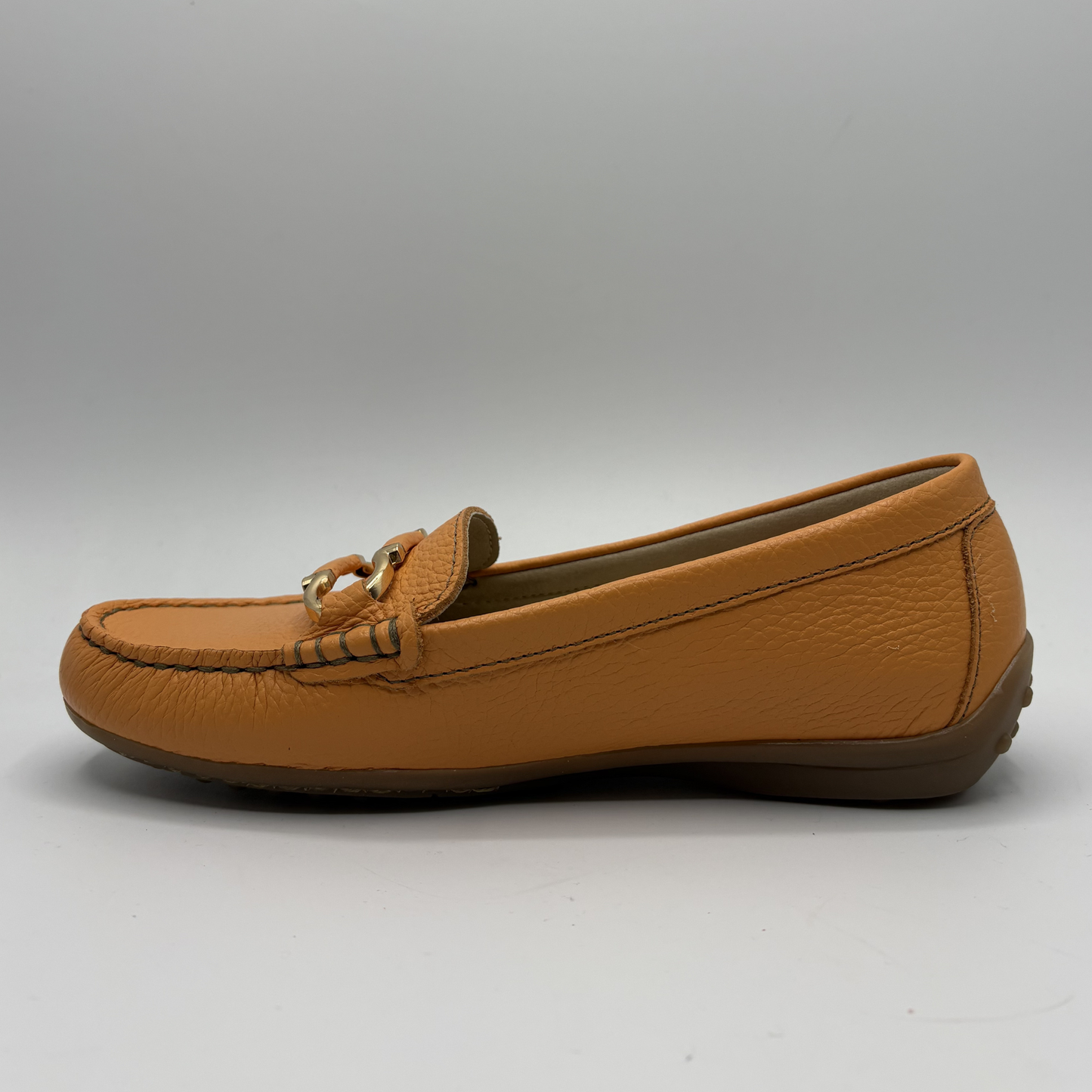 Brown loafer shoe on a gray background