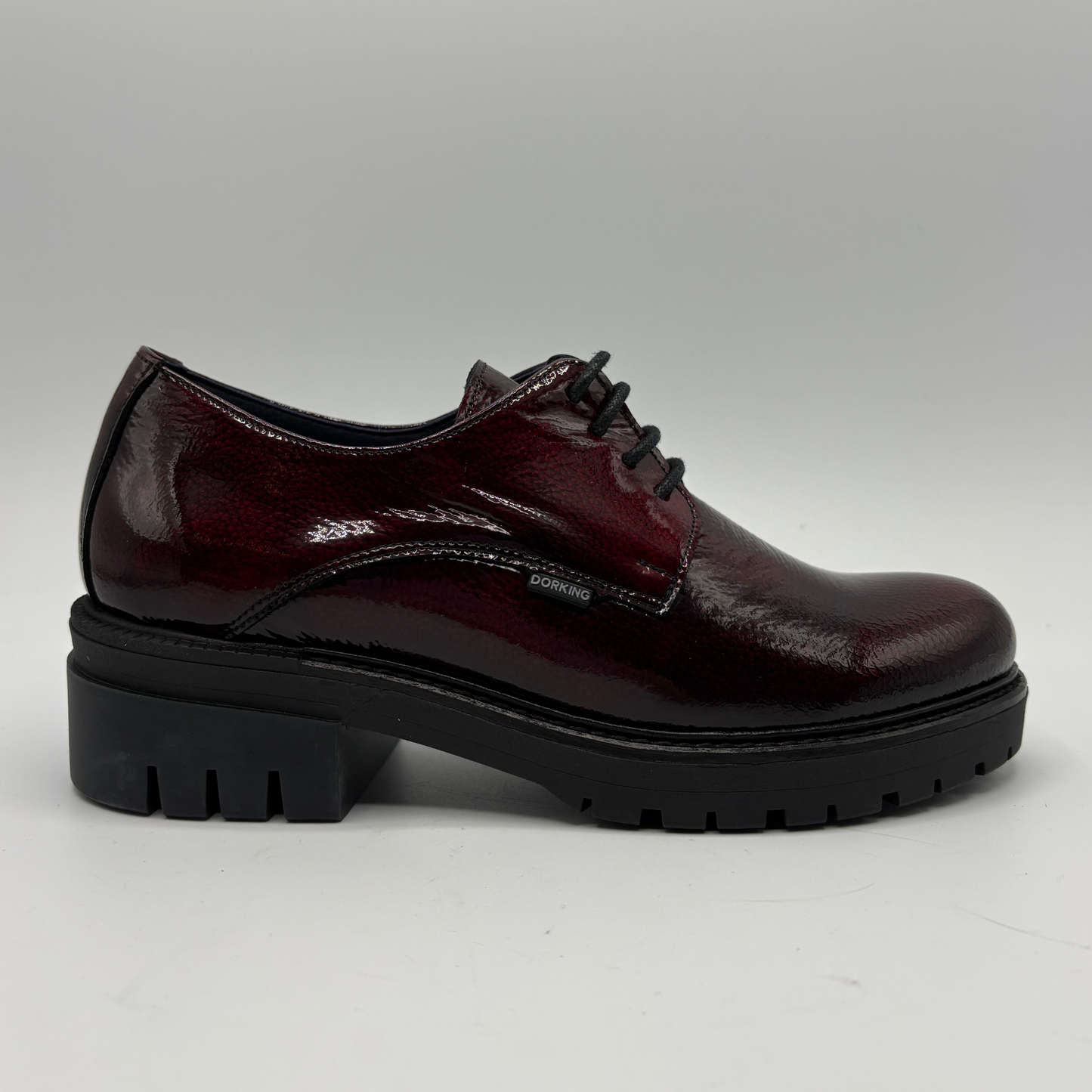 Black and green oxford shoe with a brand logo on a white background