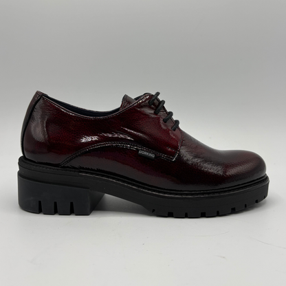 Black and green oxford shoe with a brand logo on a white background