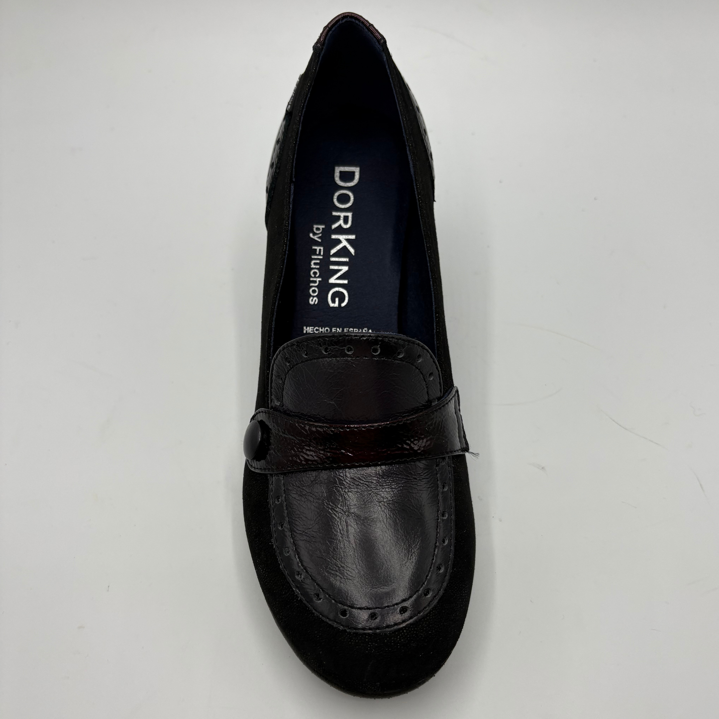 A single black Dorking by Fluchos slip-on loafer shoe with a dark brown leather strap and suede toe, photographed from a top-down angle on a light gray background.
