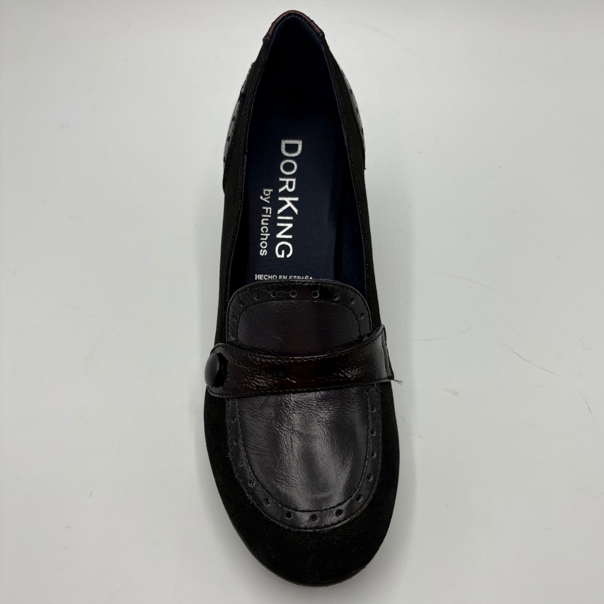 A single black Dorking by Fluchos slip-on loafer shoe with a dark brown leather strap and suede toe, photographed from a top-down angle on a light gray background.