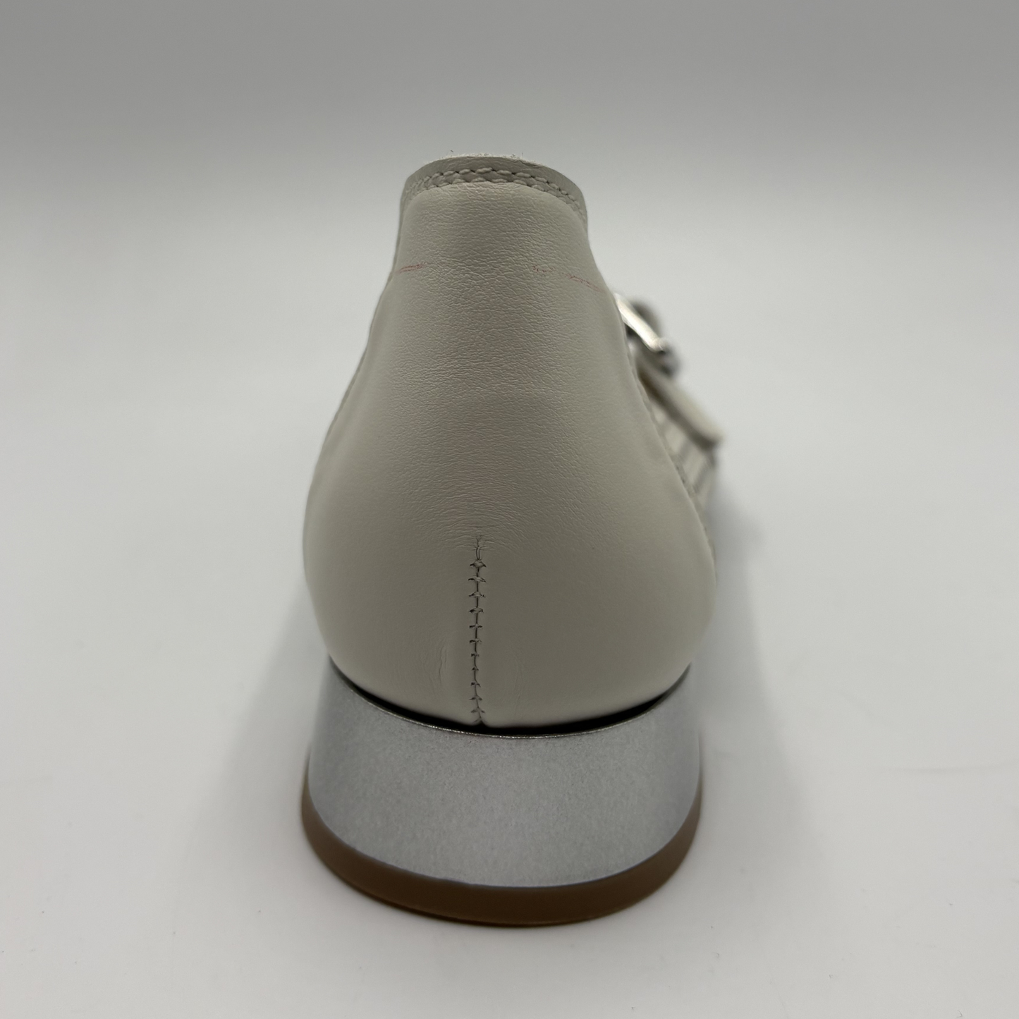Cream shoe with brown sole on a white background