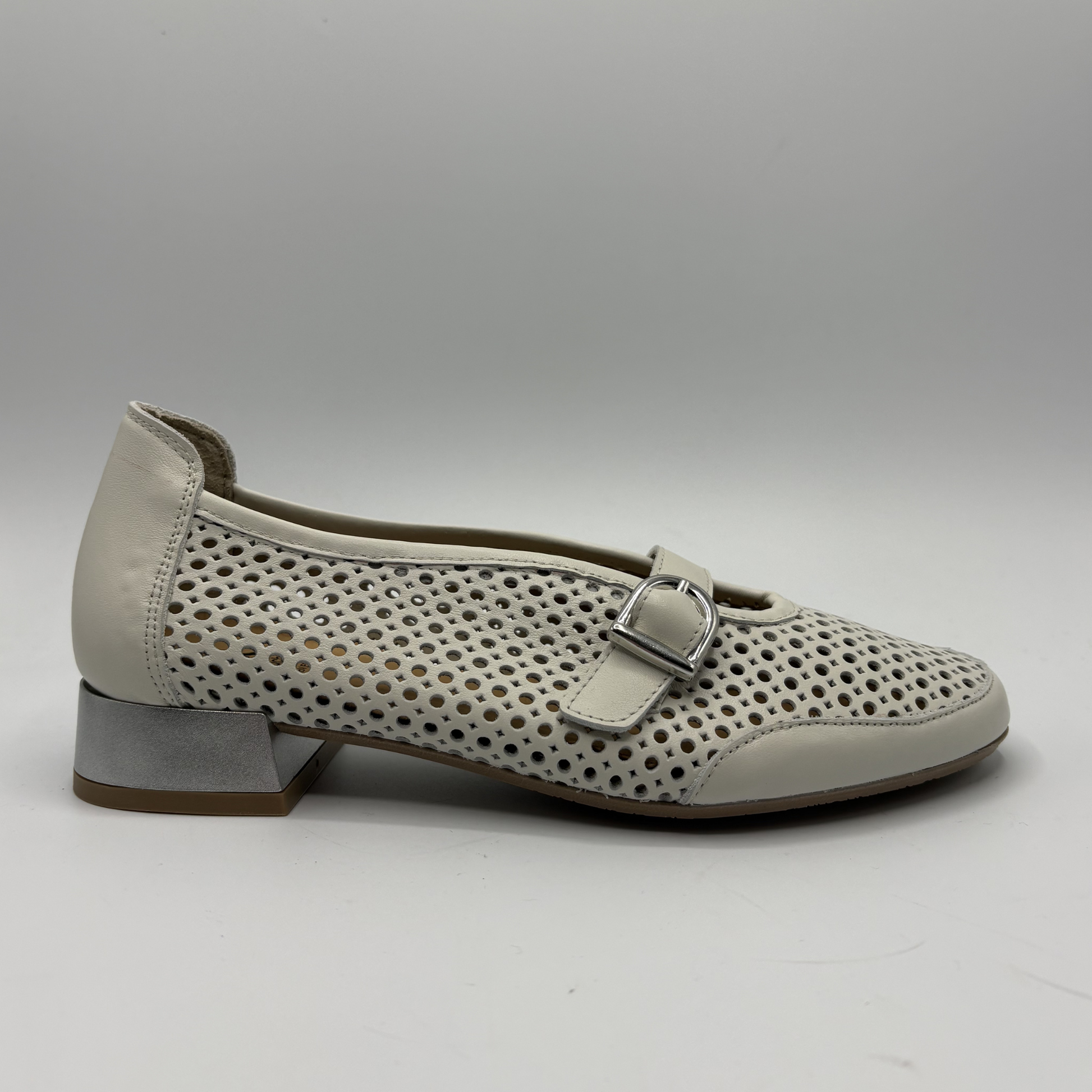 Beige shoe with perforated design and buckle on a white background