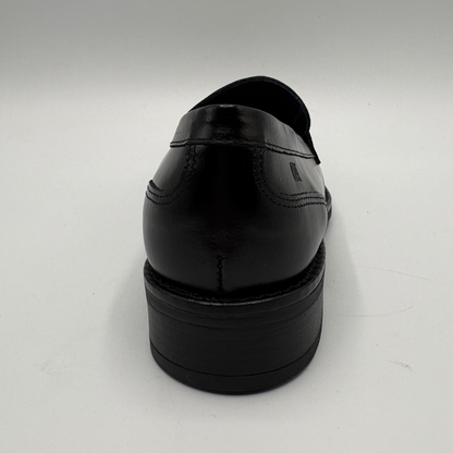 A black leather loafer with a chunky platform sole, shown from a rear three-quarter angle on a light gray background.