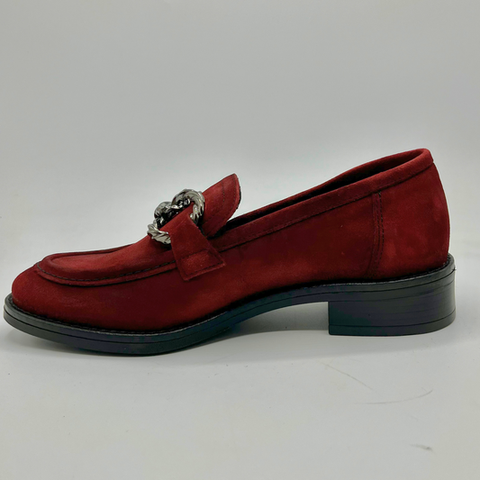 Red loafer shoe with a silver buckle on a white background