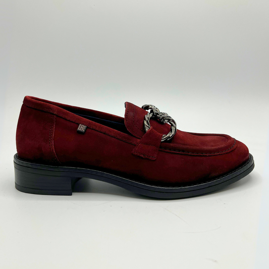 Red suede loafer with a chain detail on a white background