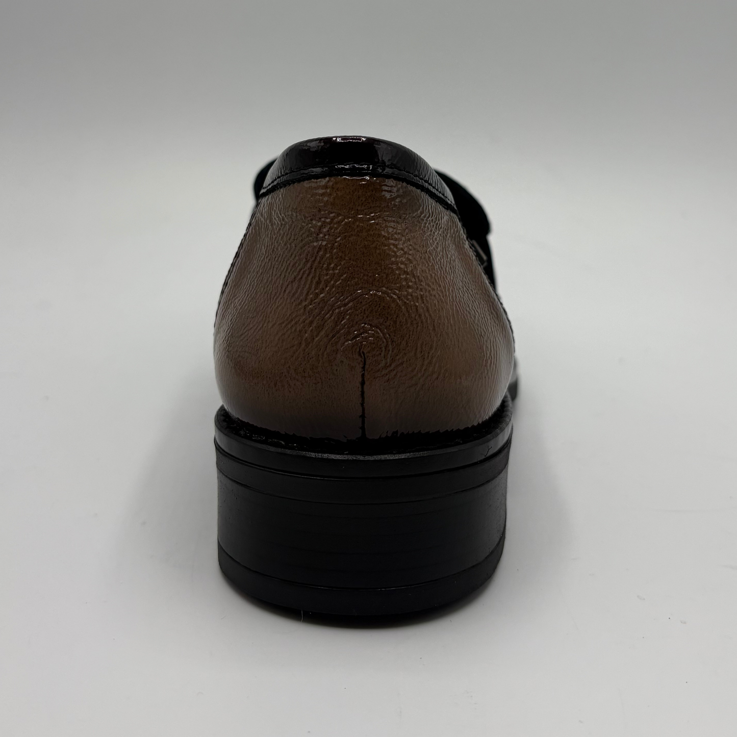 A single brown leather shoe shown from the back, featuring a textured brown upper with a glossy black heel counter and a thick black platform sole, set against a plain light gray background.