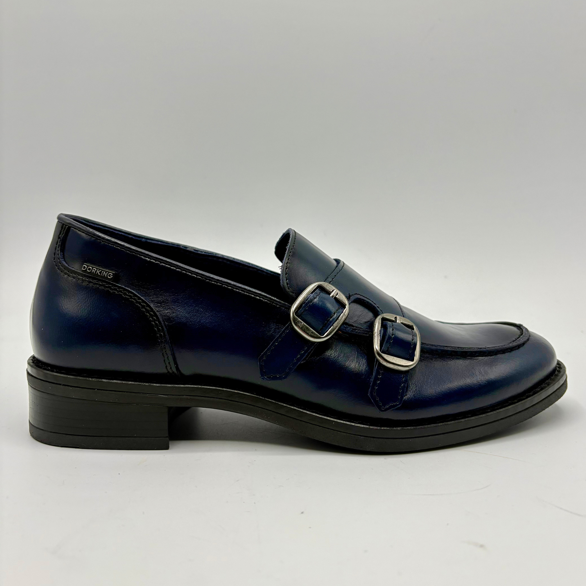 Right facing view of a blue leather loafer with two silver buckles