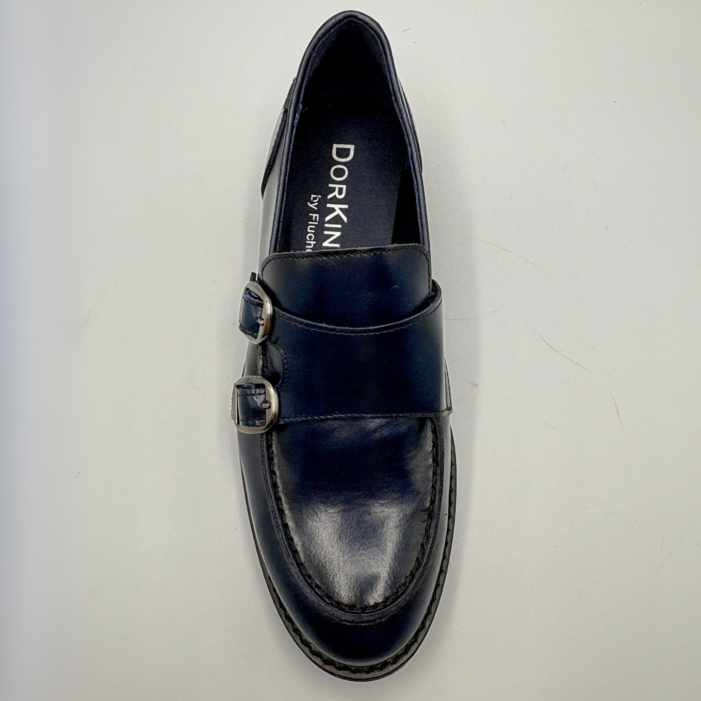 Top view of a blue leather loafer with two silver buckles