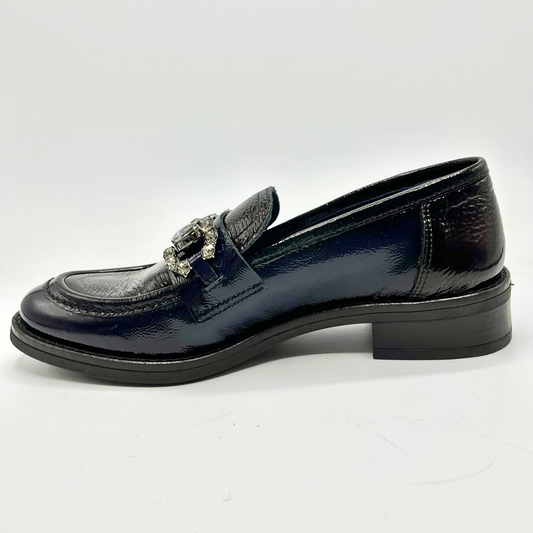 Navy patent leather loafer with decorative buckle on a white background