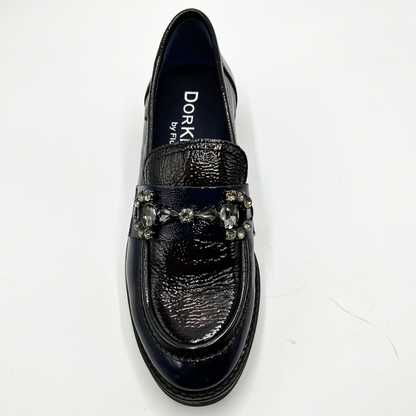 Navy loafer shoe with decorative elements on a white background