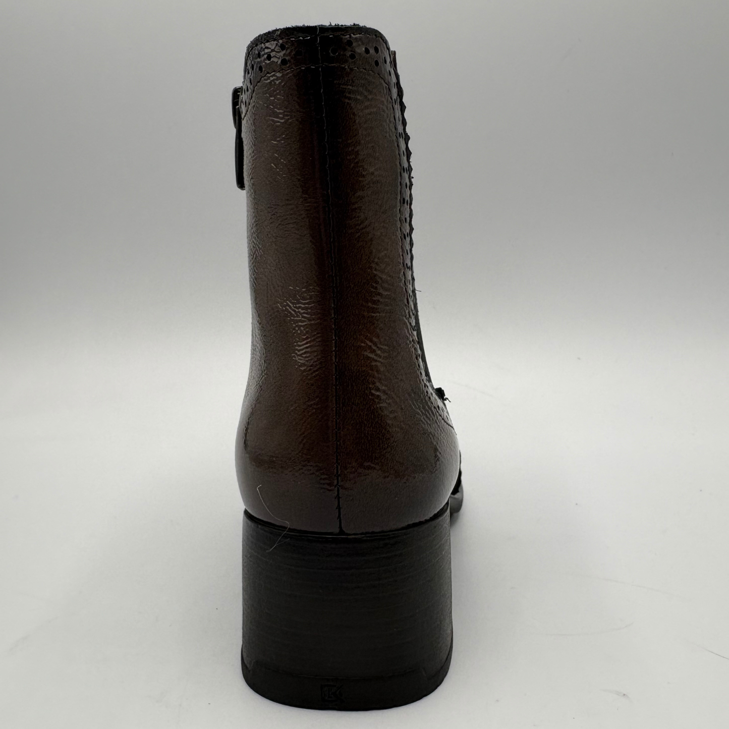 A dark brown leather ankle boot shown from the back, featuring a glossy finish, a stacked black block heel, and a side zipper.