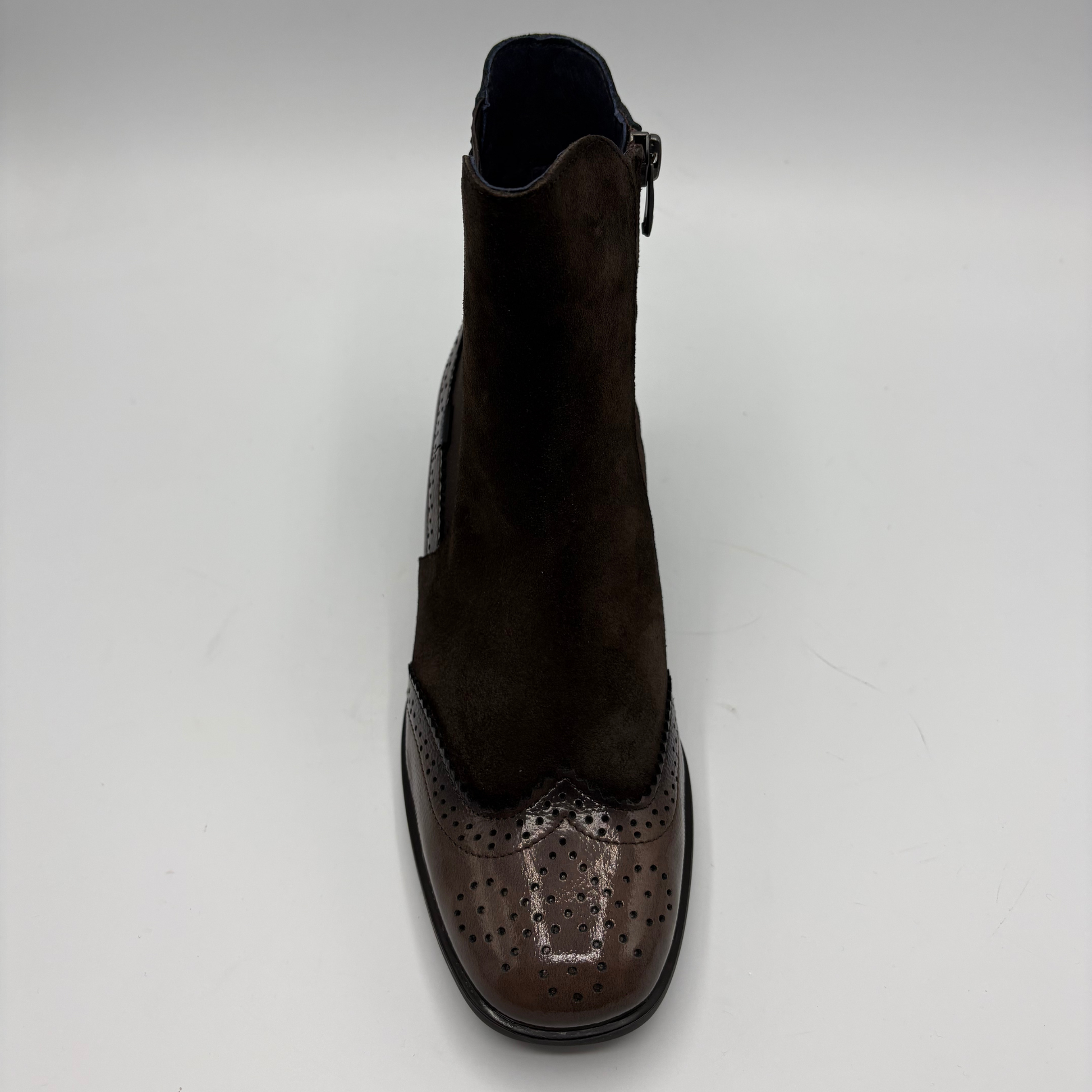 A single dark brown ankle boot with a suede upper and a glossy brogue toe cap, shown from a top-down view on a light gray background.