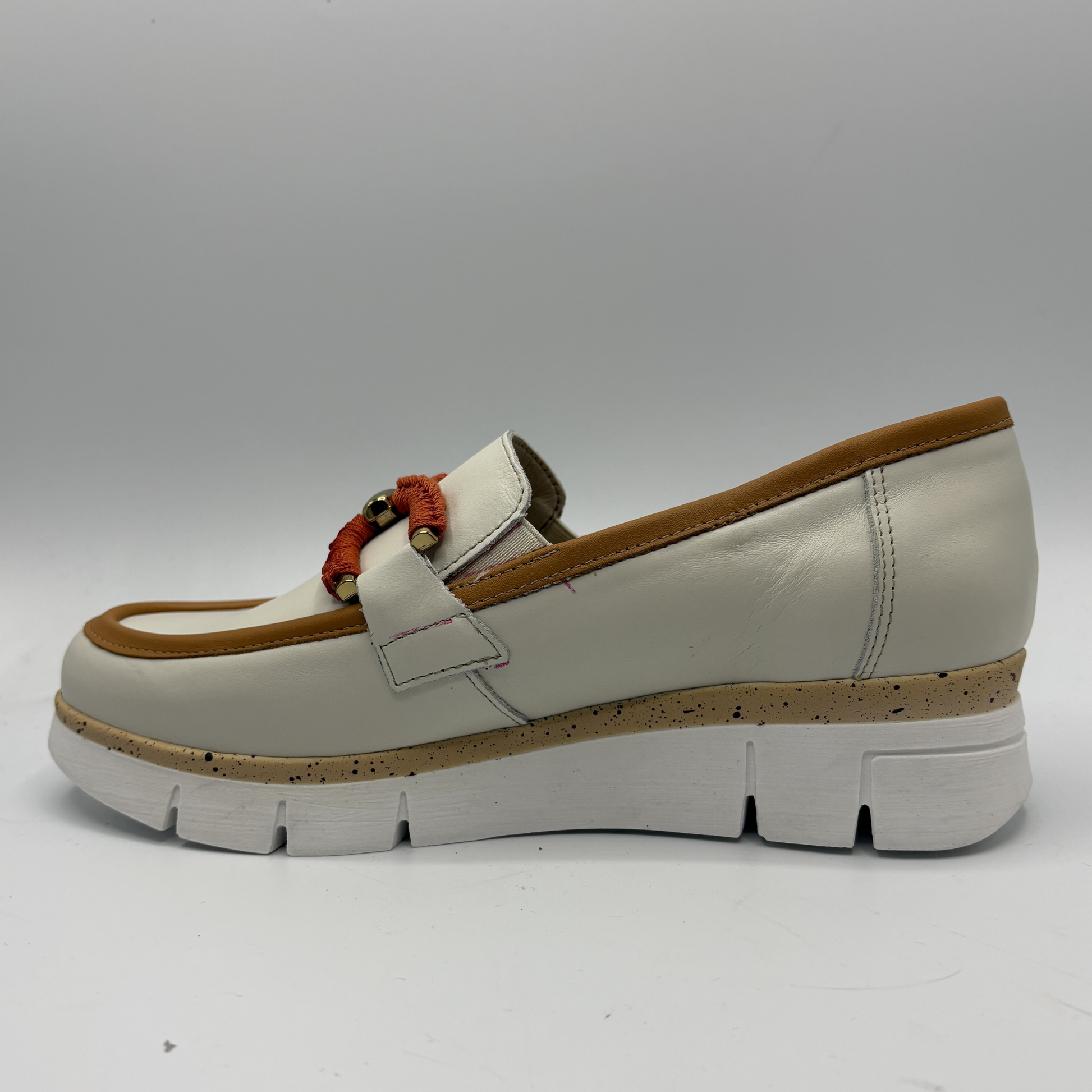 White loafer shoe with brown accents on a white background