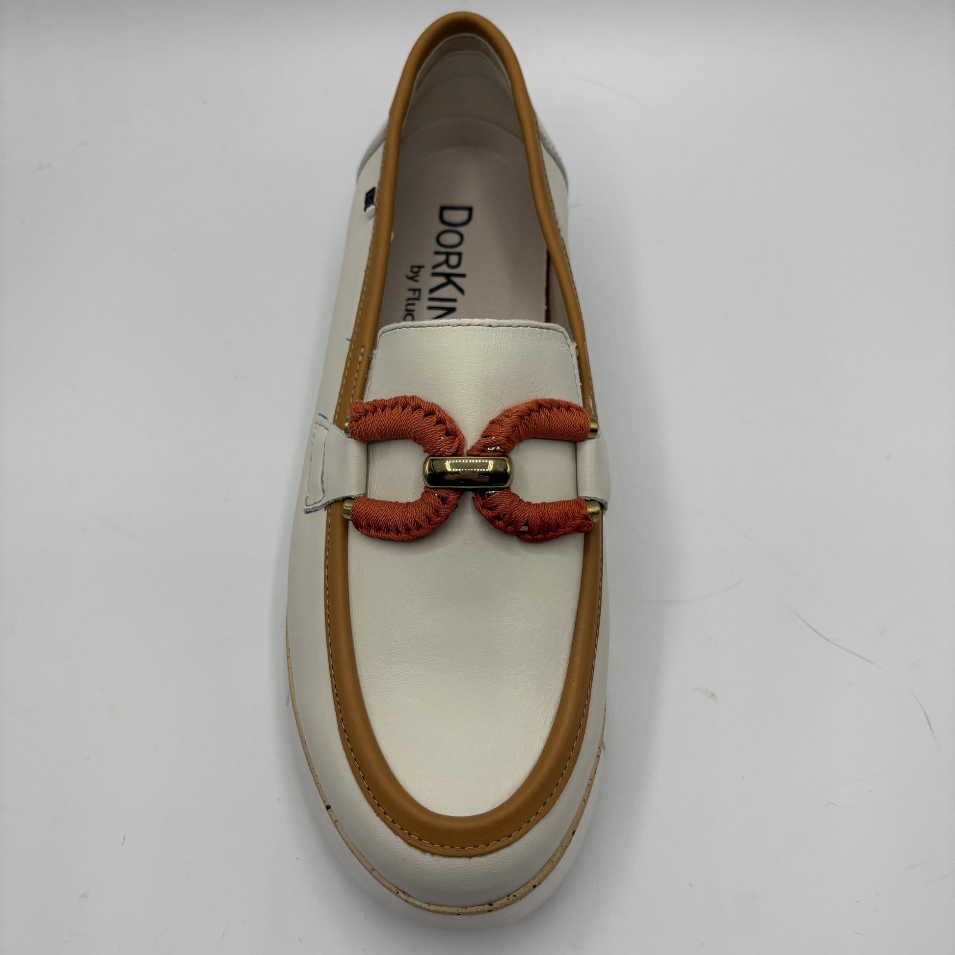 White loafer with brown accents and red bow on a white background