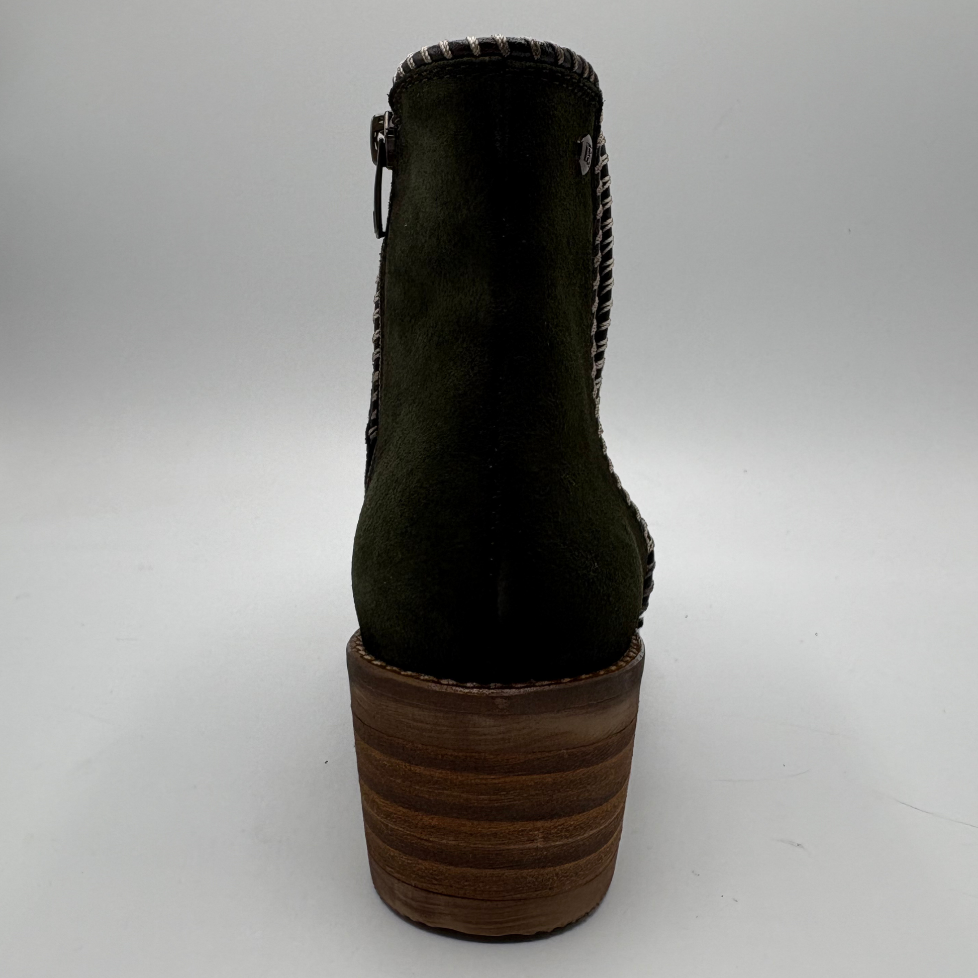 A dark olive green suede ankle boot with a chunky brown wooden block heel, shown from a rear three-quarter view against a neutral gray background.