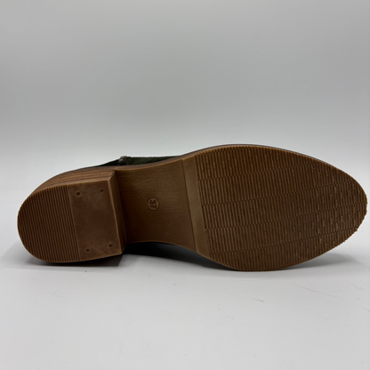The outsole of a leather boot, showing a textured brown rubber tread and a small embossed logo in the center, photographed on a light gray background.