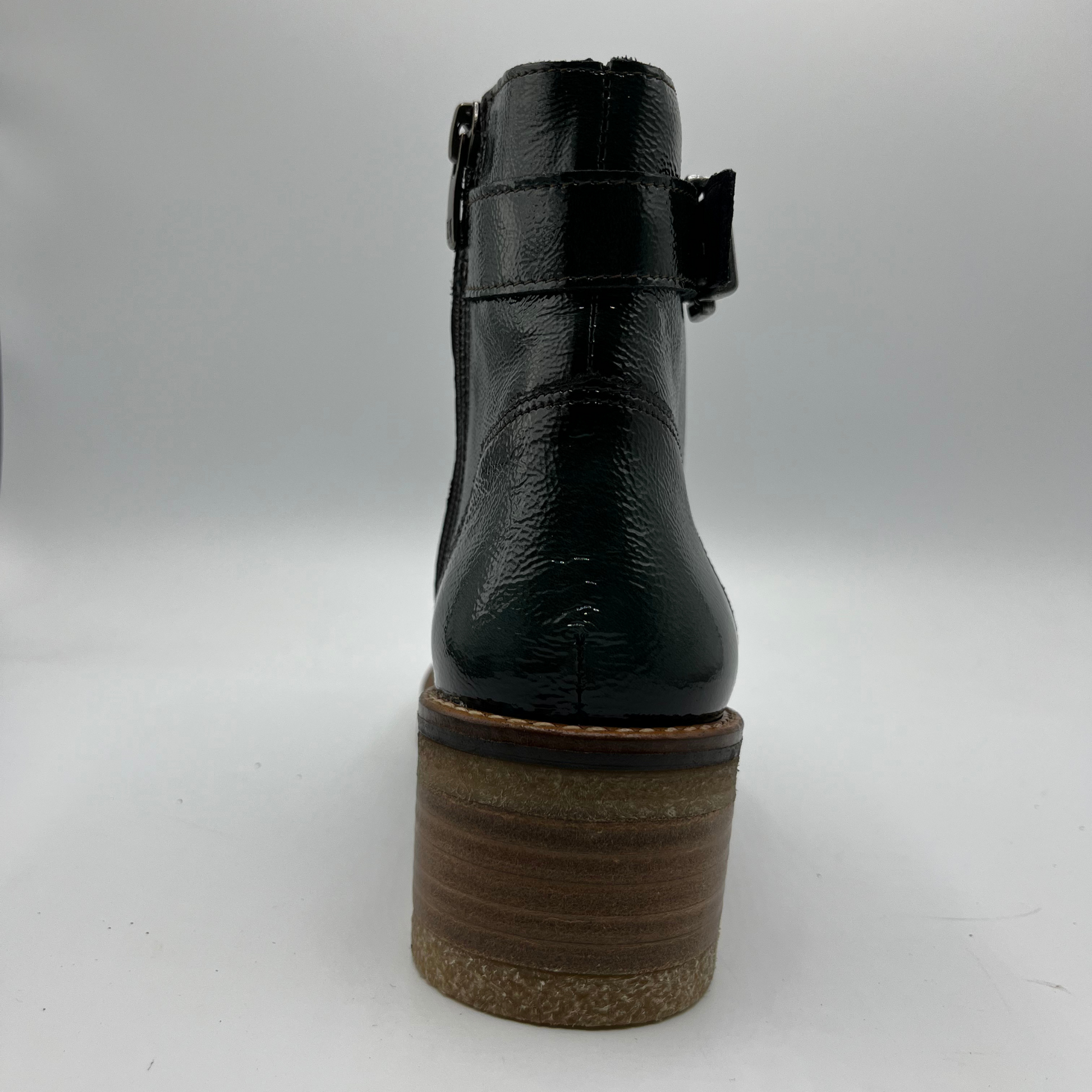 Green ankle boot with a brown sole on a white background