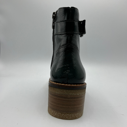Green ankle boot with a brown sole on a white background
