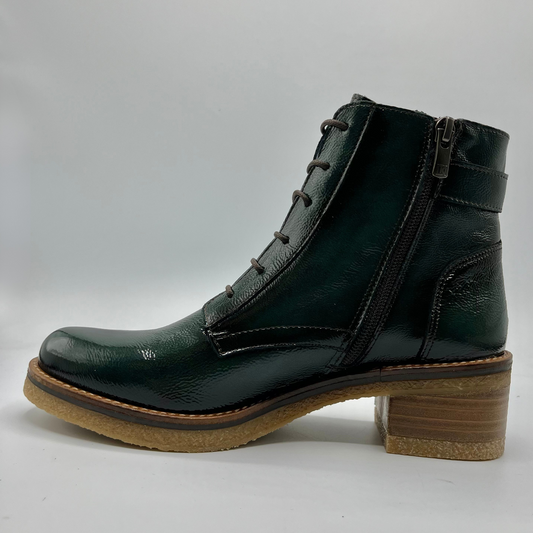Green leather boot with a brown sole on a white background