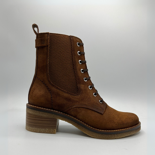 Brown suede boot with a block heel on a light gray background