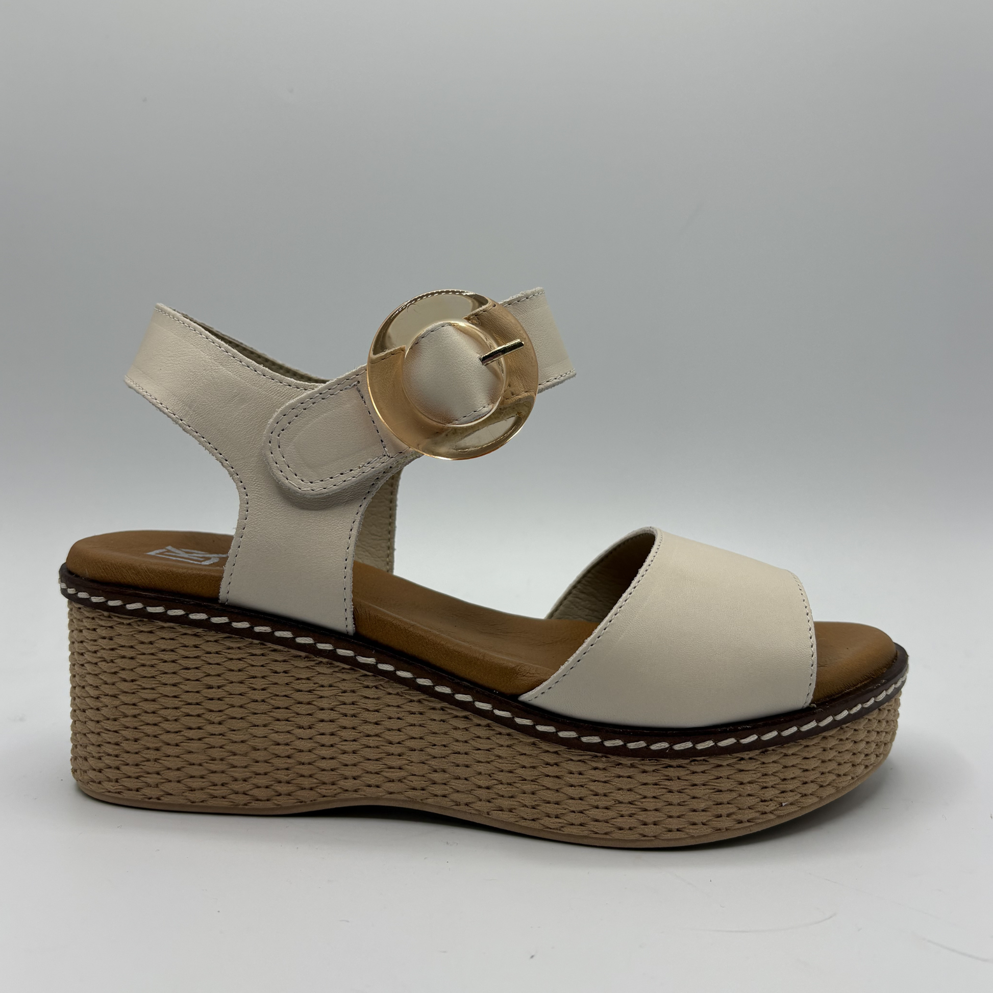 Beige sandal with a brown wedge sole on a gray background