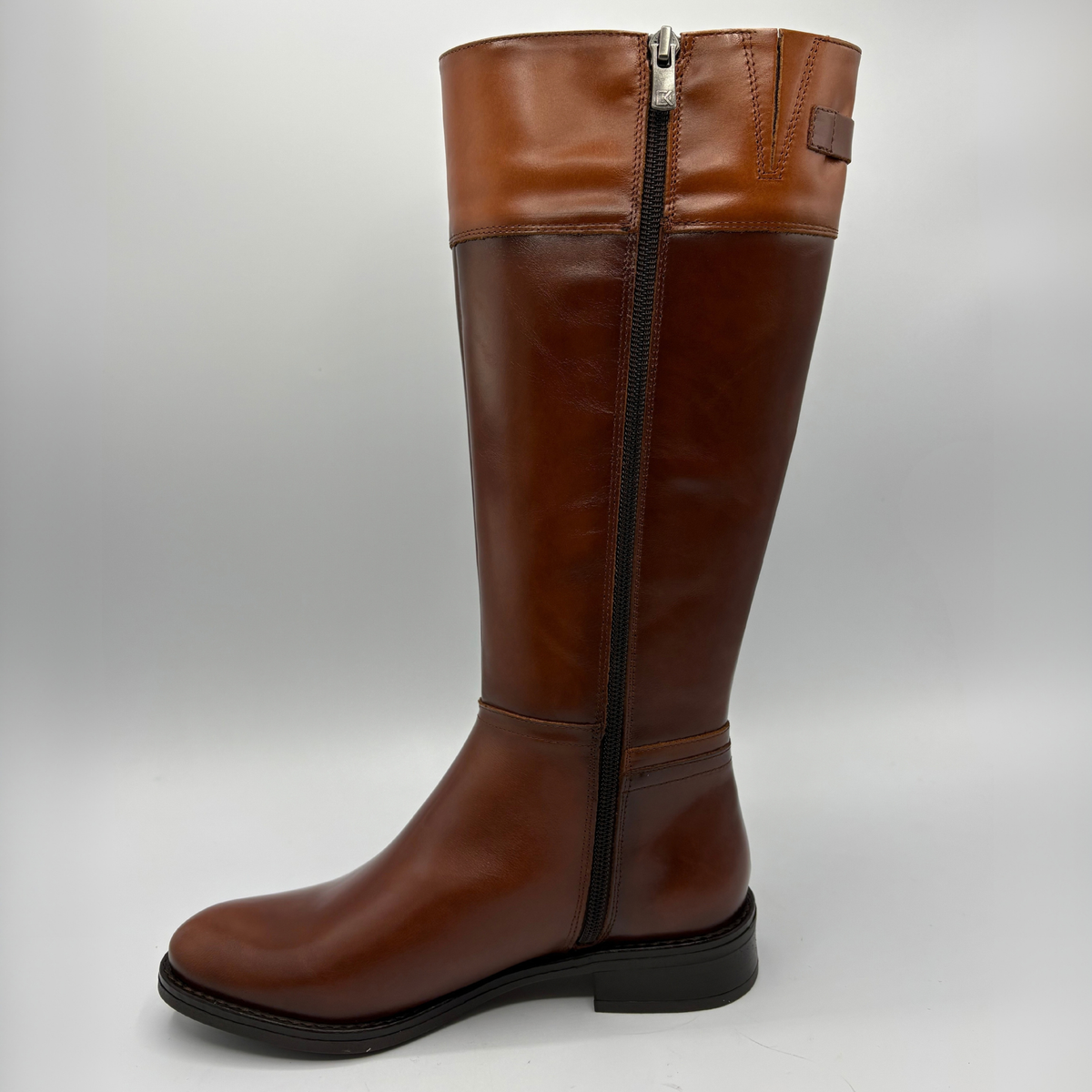 Left view of a tall brown leather boot with a decorative buckle and low black heel
