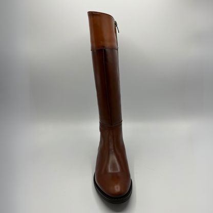 Front view of a tall brown leather boot with a decorative buckle and low black heel