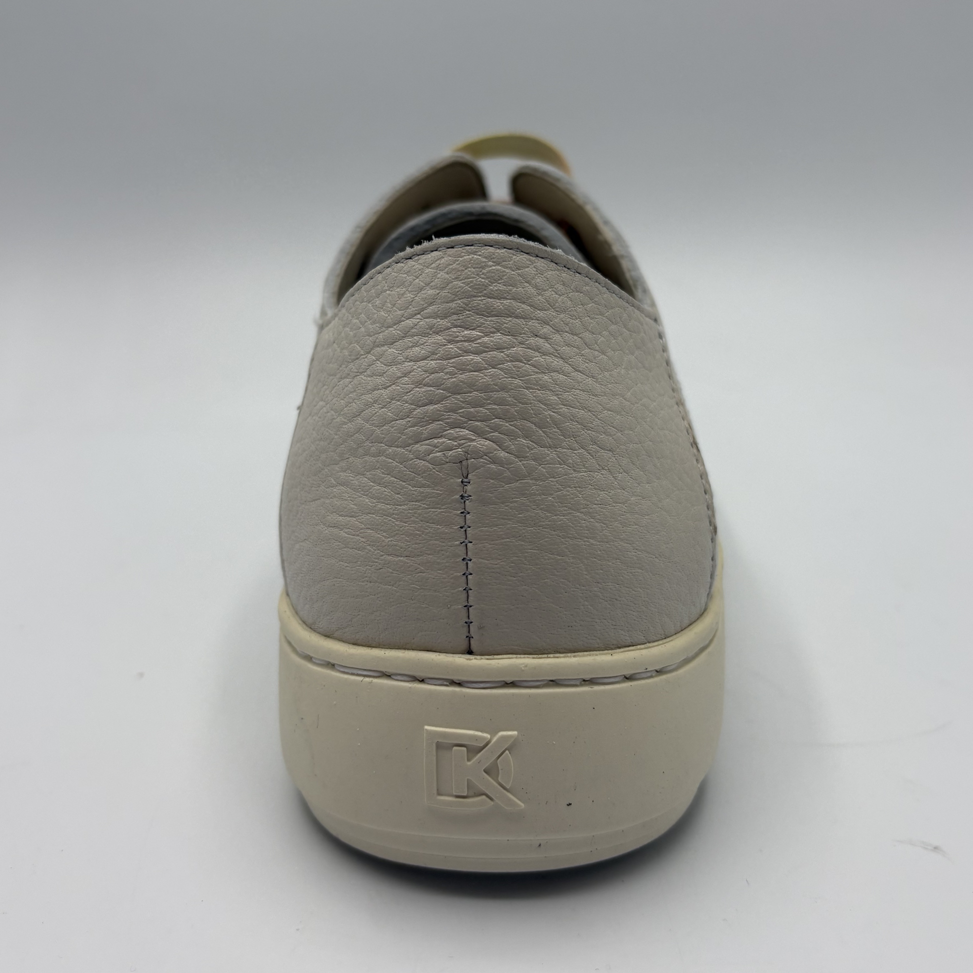 Gray slip-on shoe with a brand logo on a white background