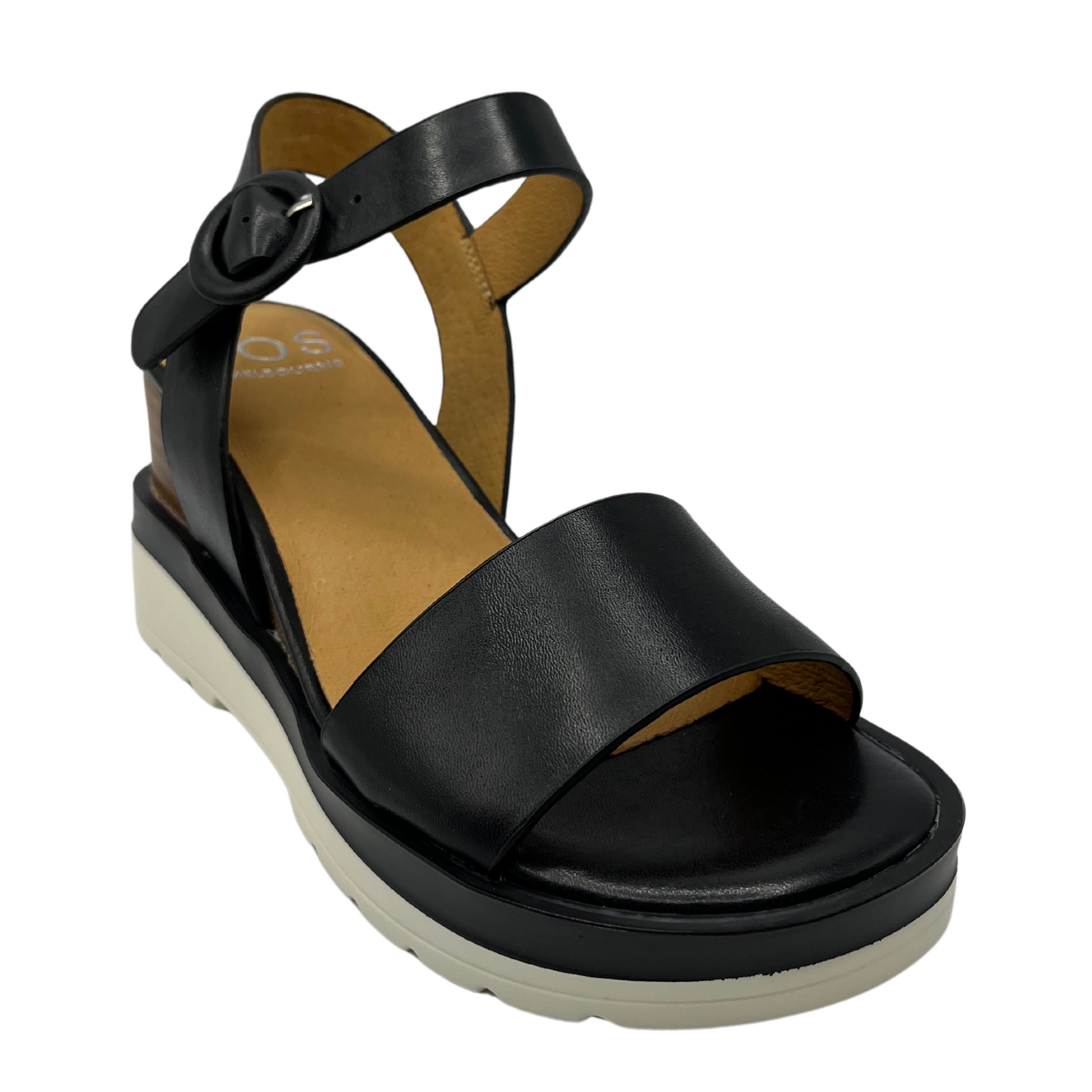 45 degree angled view of black wedge sandal with buckle ankle strap, rounded toe with black and white rubber outsole