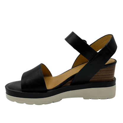 Left facing view of black leather sandal with stacked wedge heel