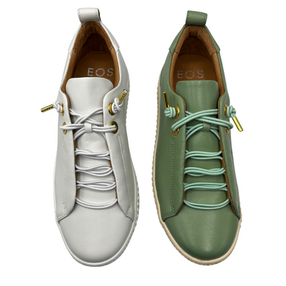 Top view of one white sneaker and one green sneaker. Both have matching laces and rounded toe