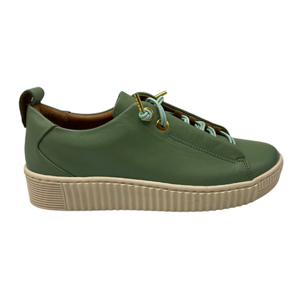 Right facing view of basil green leather sneaker with off white rubber outsole