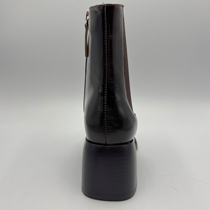 Back view of a dark brown short boot with an elastic side panel and a block heel