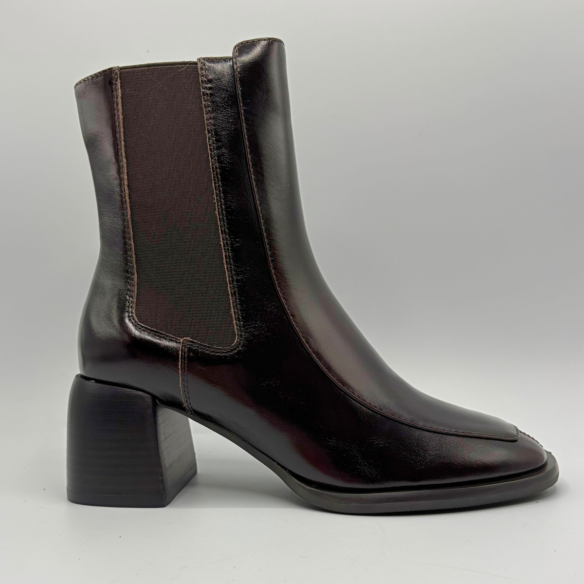 Right facing view of a dark brown short boot with an elastic side panel and a block heel