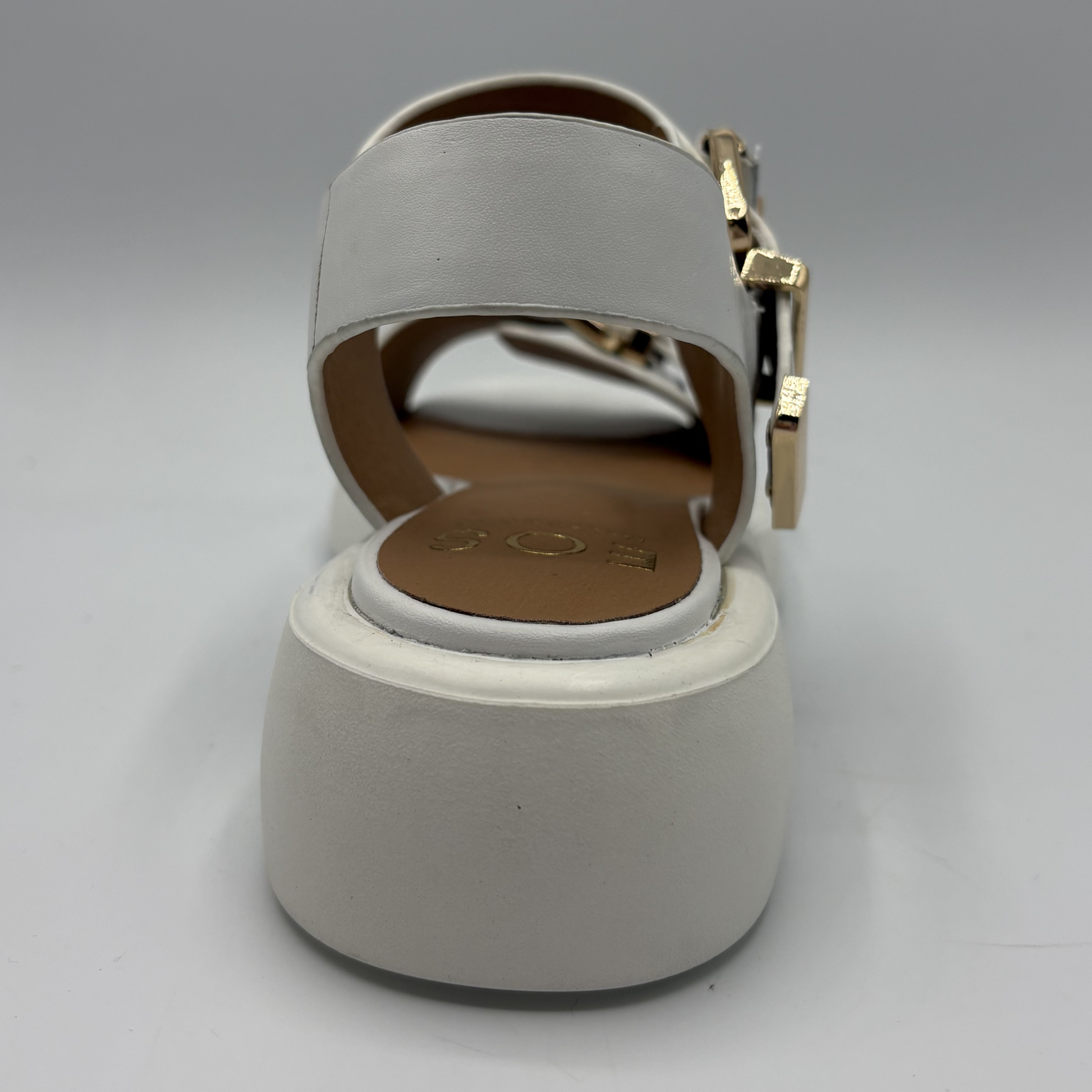 Gray sandal with a gold buckle on a gray background