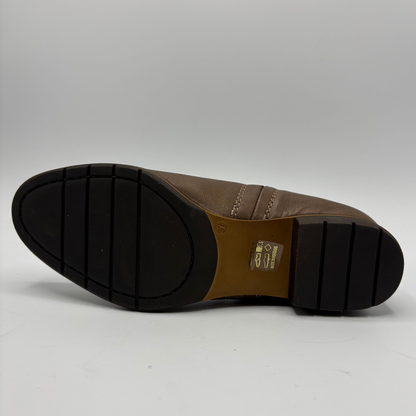 The outsole of a brown leather shoe, showing a black treaded rubber bottom and a tan heel counter with a size 8.5 label.