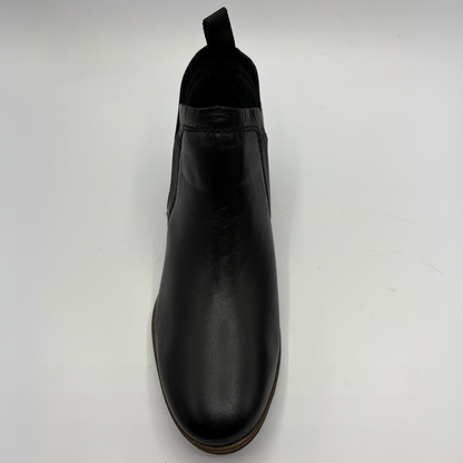 A single black leather Chelsea boot with a pull tab, shown from a top-down perspective on a light gray background.