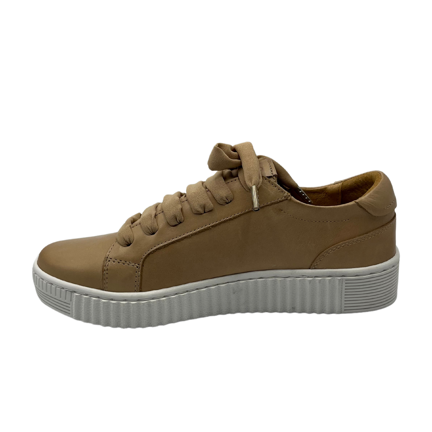 Left facing view of nude leather sneaker with white rubber outsole