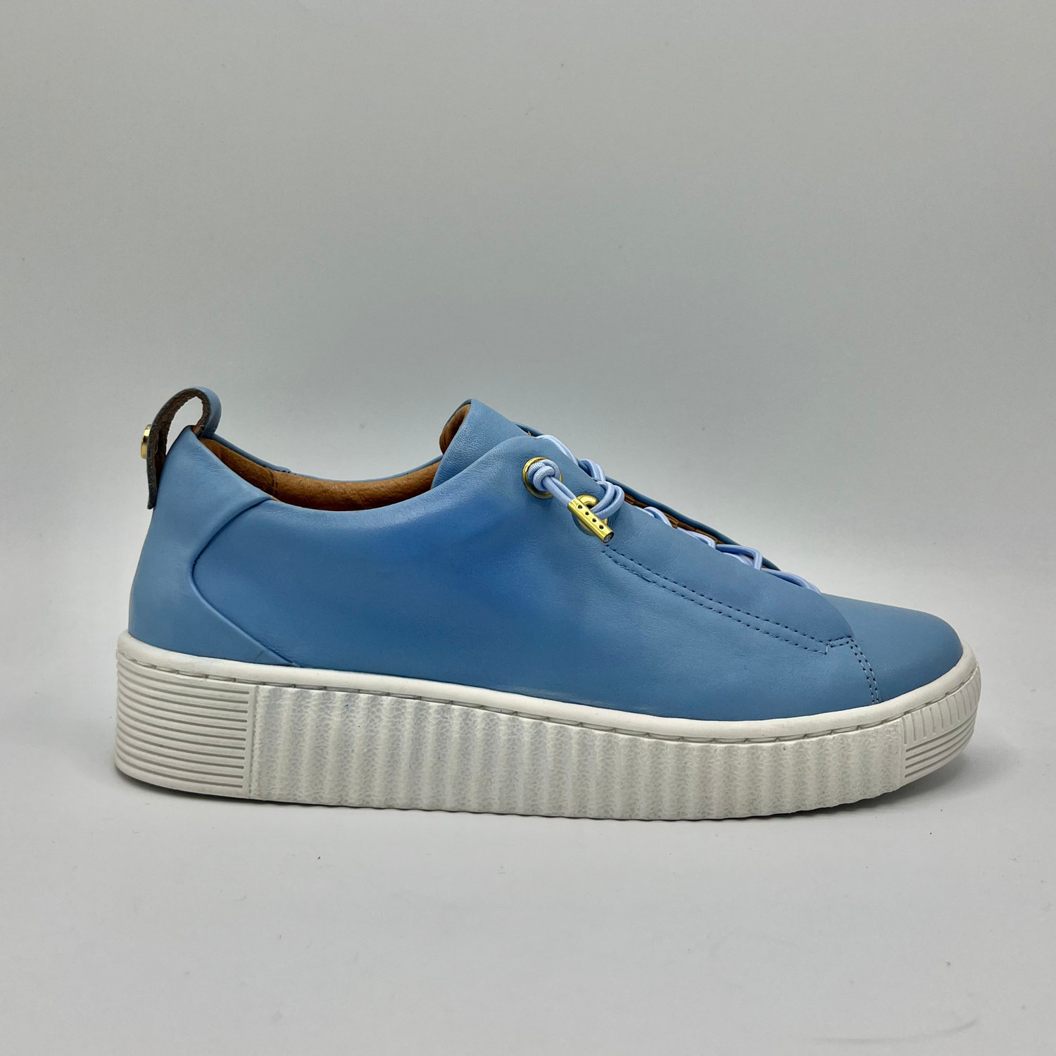 Right facing view of a blue leather sneaker with off white rubber outsole with matching elastic laces 