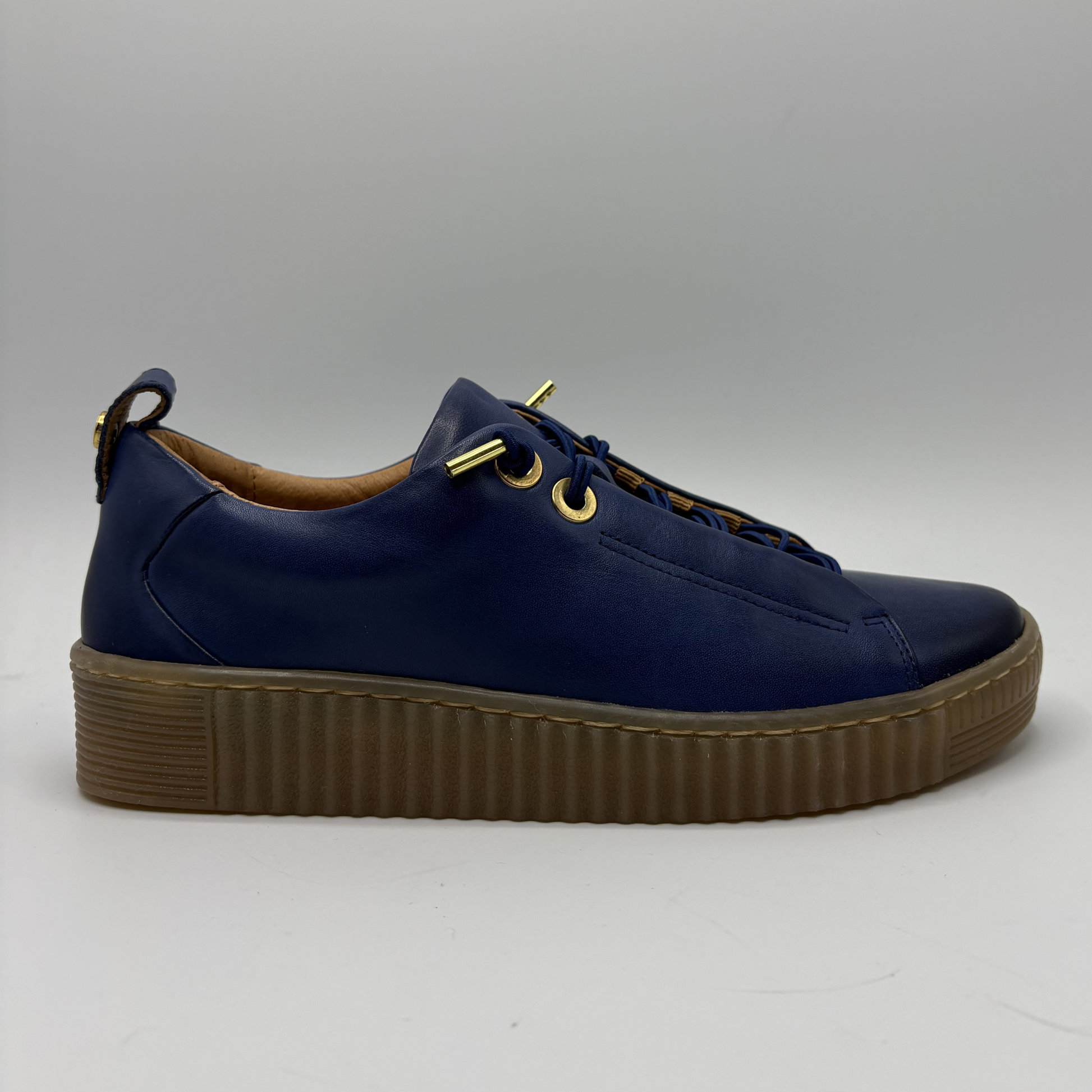 Blue sneaker with brown sole on a white background