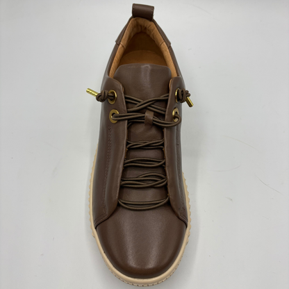 A brown leather lace-up sneaker with gold-tone metal eyelets and a beige rubber sole, photographed from a top-down angle on a light gray background.
