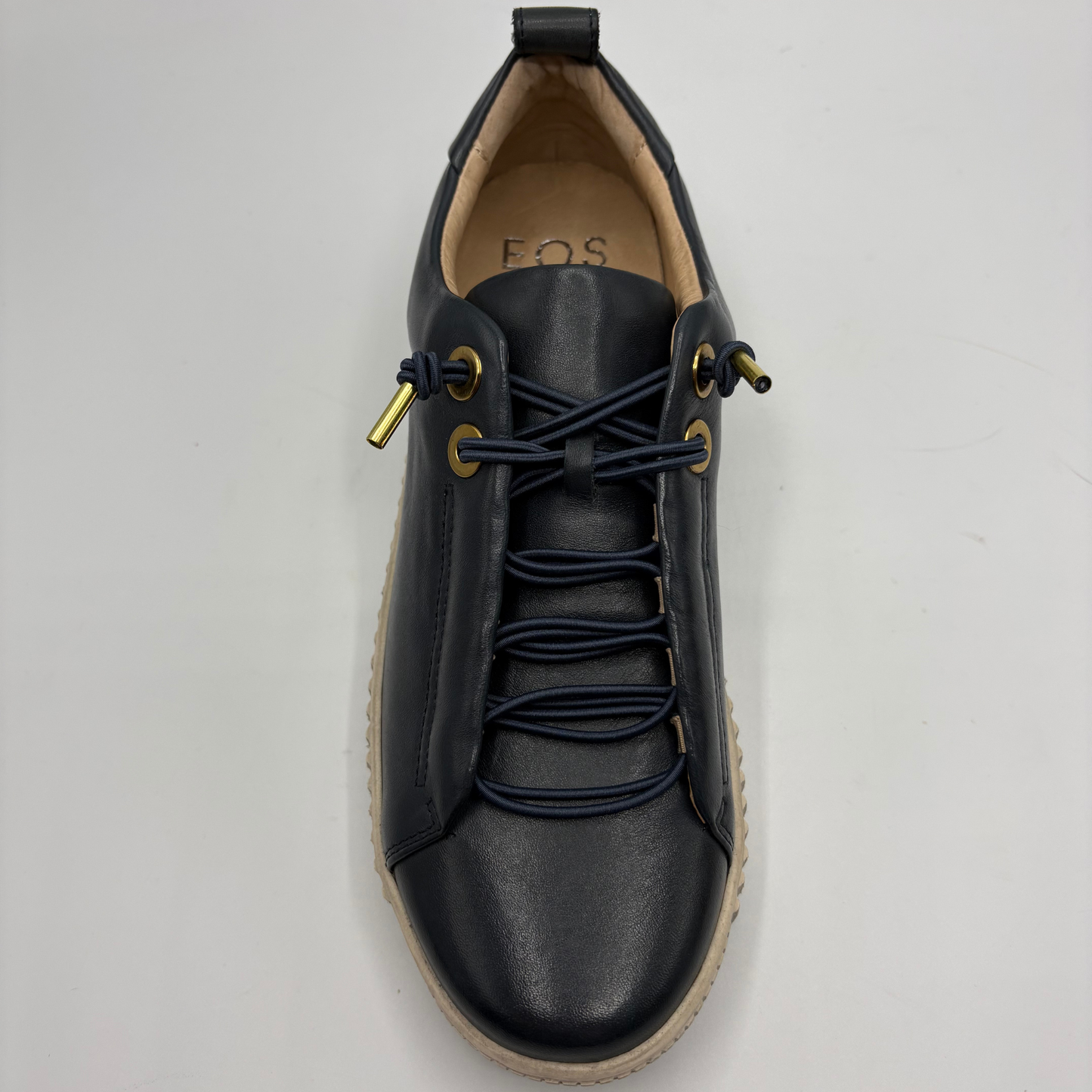 A single dark navy leather lace-up shoe with matching navy laces, gold-tone eyelets and pull tabs, and a beige sole, shown from a top-down angle on a light gray background.