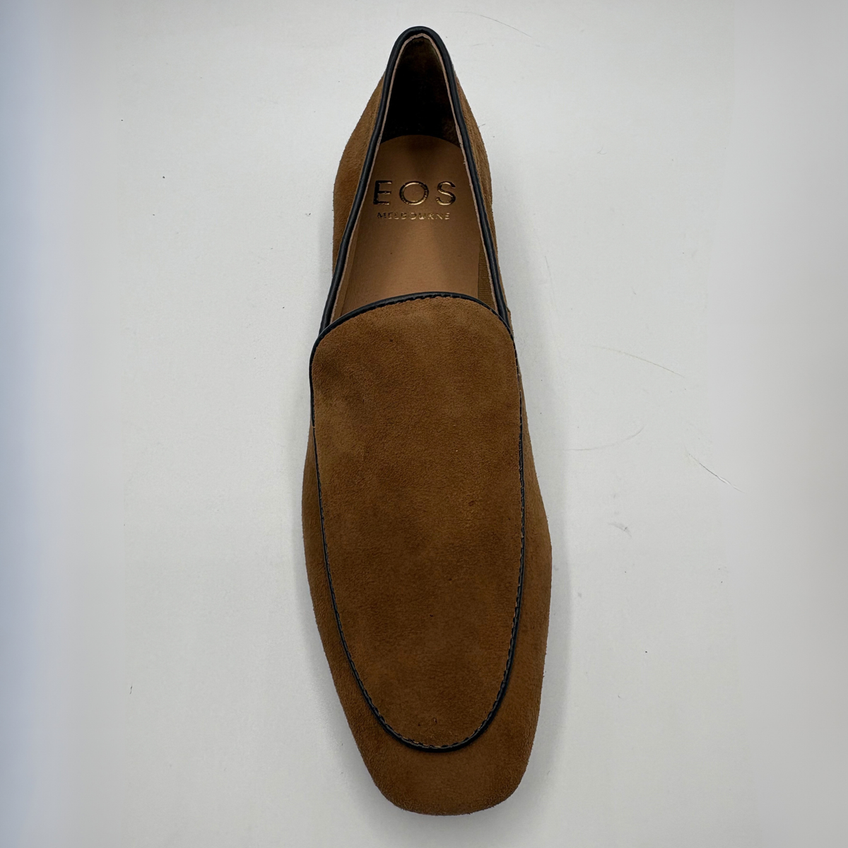 Top view of a brown leather loafer with a short stacked heel on a white background