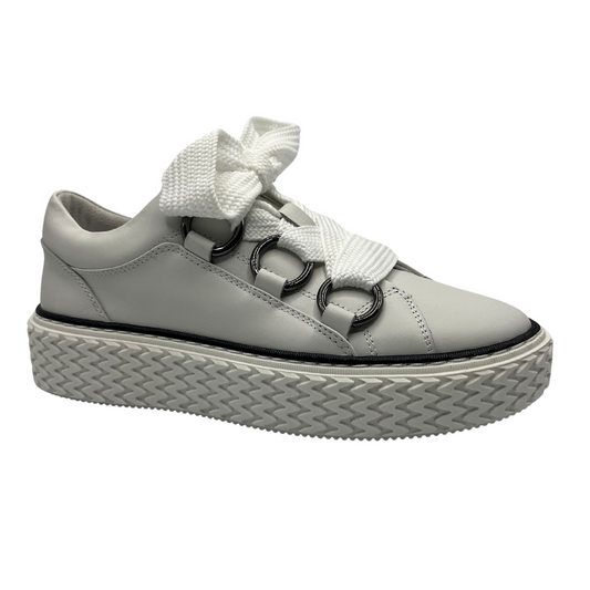 45 degree angled view of white leather sneakers with wide laces, white rubber outsole and large grommets. 