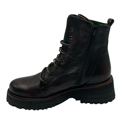 Left facing view of berry leather combat boot with zipper closure and maroon and green laces