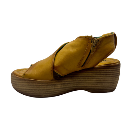 Left view of mustard coloured leather sandals with chunky wedge sole and sling back strap