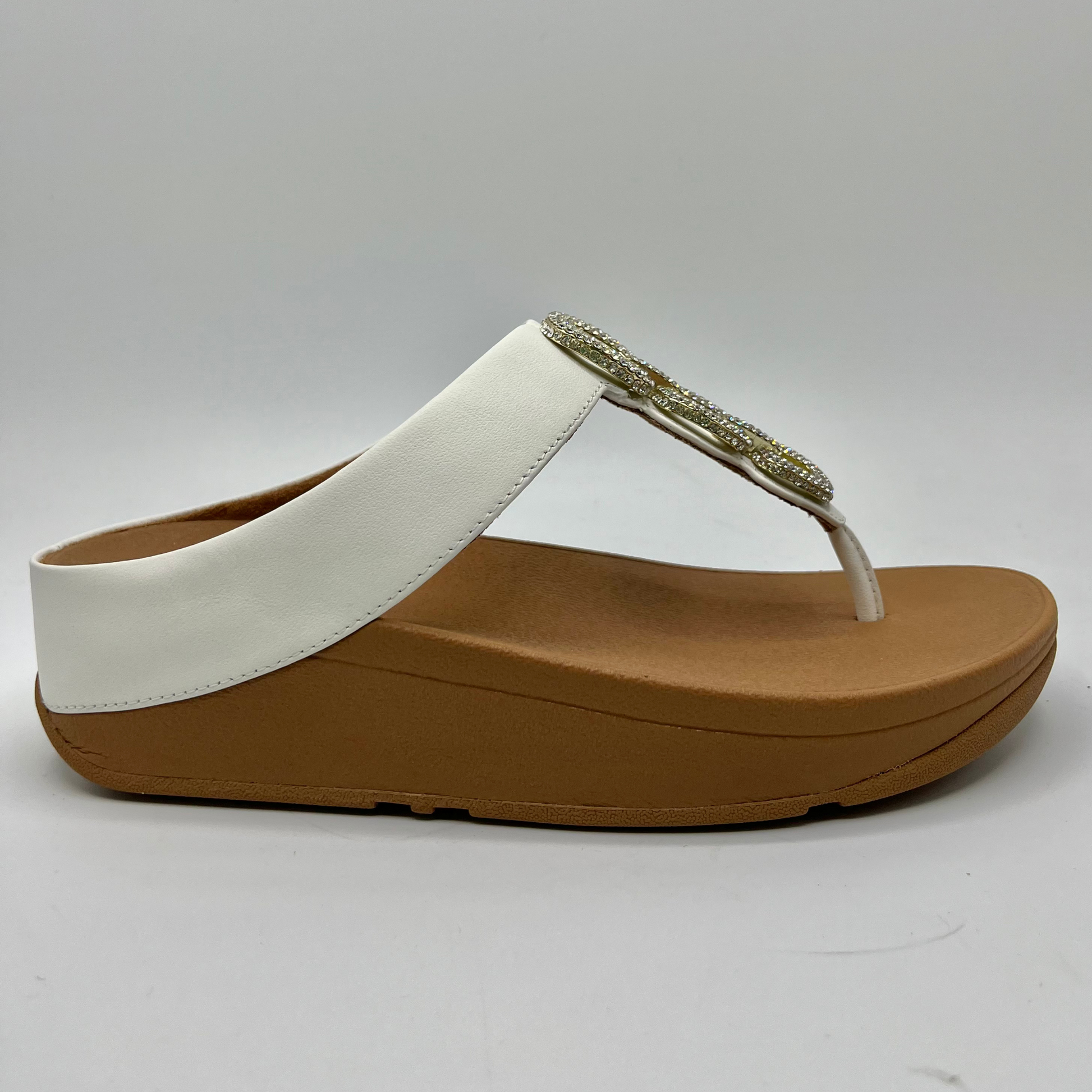 Right facing view of a leather wedge sandal with a white strap and toe post. Featuring a crystal chain detail on the strap.